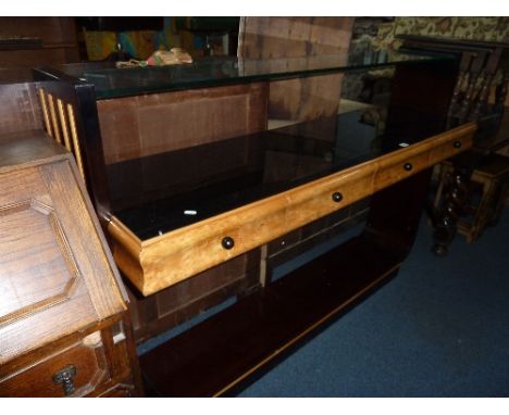 A MODERN ART DECO STYLE MAPLE AND EBONISED SIDE CABINET, the upper section with glass shelf above four drawers and lower shel