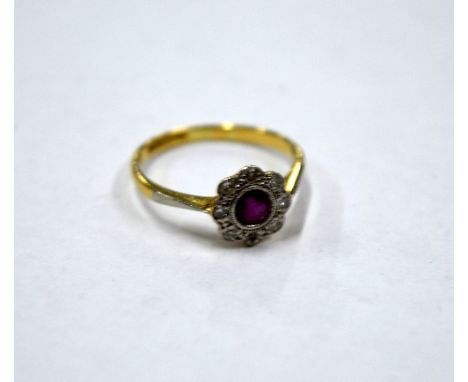 AN 18CT GOLD RUBY AND DIAMOND RING, of daizy shape with central ruby within a surround and single cut diamonds, stamped PLAT 