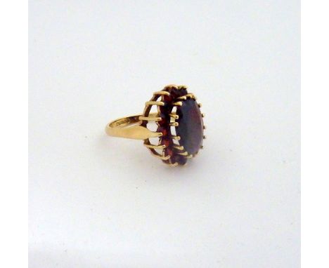 A 9CT GOLD GARNET CLUSTER RING, with large central oval garnet to a surround of smaller circular garnets, hallmarks for Birmi