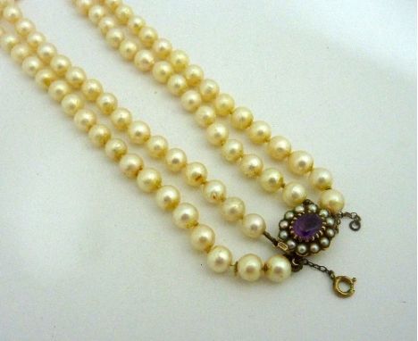 A PEARL NECKLACE, comprising of a double row of pearls with an amethyst cluster clasp within a surround of smaller pearls, le