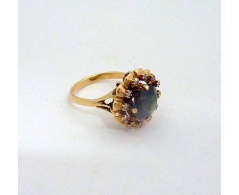 A TOURMALINE AND DIAMOND RING, with circular tourmaline within a surround of single cut diamonds within a scalloped border to