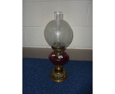 A BRASS OIL LAMP, ruby coloured glass well and glass shade, height approximately to top of shade 47cm     