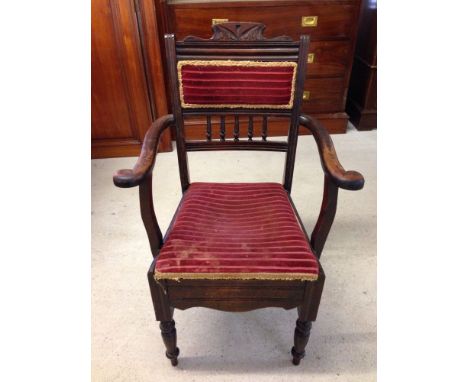 A mid Victorian stained beech commode chair converted to a carver armchair with spindle panelled back and turned legs to fron