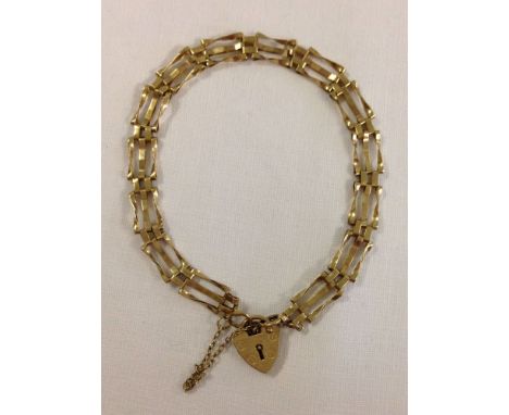 Hallmarked 9ct gold 3 bar gate bracelet with heart shaped padlock clasp and safety chain. Length approx 7", weight approx 3.8