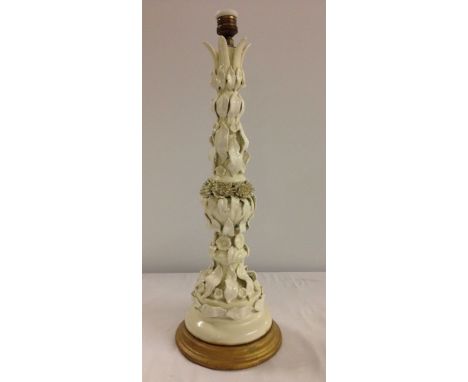 A tall antique continental majolica table lamp in white glaze approx 63cm tall. Slight damage to central flower heads.