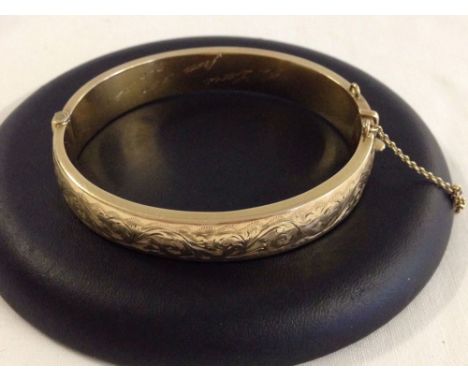 Hallmarked 9ct gold bangle with engraved decoration. Safety chain broken, 2 slight dents and the inside has been engraved 'To