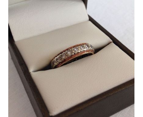 A gold & white sapphire eternity ring - tests as 12ct gold, size M.