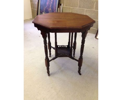 A Victorian centre table with fretwork to centre shelf, turned legs & columns to shelf. China casters.