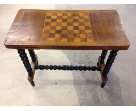 A mahogany games table with inlaid chess/draughts board, 2 slimline drawers on opposing sides for draughts pieces and black s