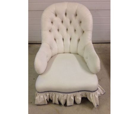 A Victorian covered spoonback armchair with deep button white & lilac upholstery. China casters to rear legs.