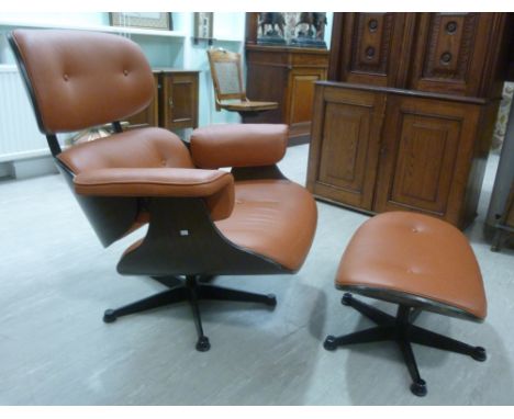 A 1970s replica Eames Lounge chair and a matching stool, button upholstered in tan coloured faux hide  