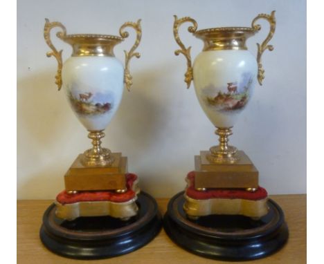 A pair of early 20thC lacquered brass and painted porcelain, twin handled, ovoid shaped sidepiece vases, decorated with stag 