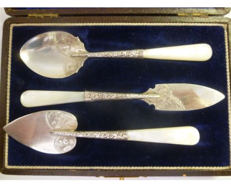 A three piece silver presentation conserve spoon, butter knife and small cake slice with foliate scrolled ornament, on mother