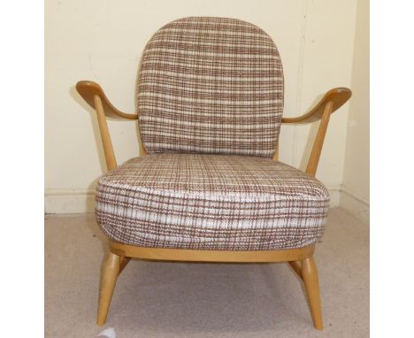 An Ercol pale beech framed Windsor style recliner open arm chair with an angled, round, spindled back, the strapworked seat a