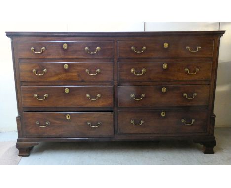 An early 19thC mahogany chest, the hinged top over four short facsimile drawers and four matching drawers with cast brass bai
