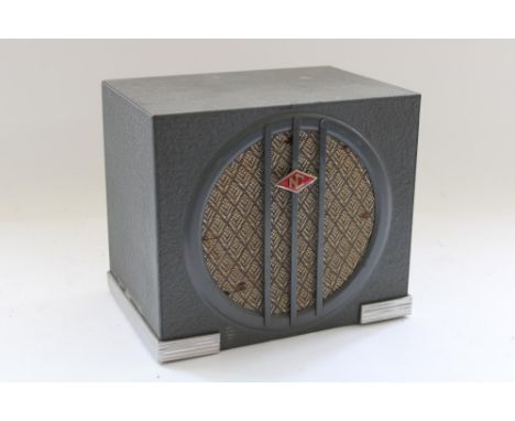 c1930s Art Deco speaker, the grey metal case with chromed reeded foot and central enamel 'NC' badge over circular soft grille