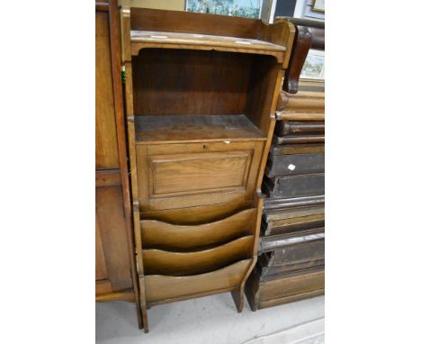 An early 20th Century oak stationery cabinet with shelf/drop flap and magazine section