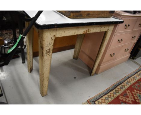 An early 20th century utility table with metal frame and enamel table top