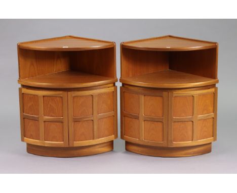 A pair of Nathan teak bow-front dwarf corner cabinets each with an open recess above a cupboard enclosed by a pair of panel d