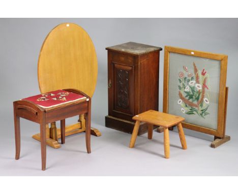 An early 20th century pot cupboard enclosed by a carved panel door, 15” wide x 29” high; together with a firescreen; a tilt-t