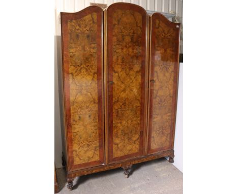 A mid-20th century burr-walnut wardrobe in the Queen Anne-style having a fitted interior enclosed by three panel doors, &amp;