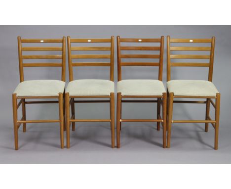 A set of four teak ladder-back dining chairs with padded seats, &amp; on round tapered legs with spindle stretchers.