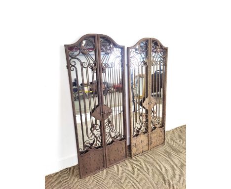 GARDEN MIRRORS, a pair, with metal gate frames, 129cm H x 52cm w. (2)