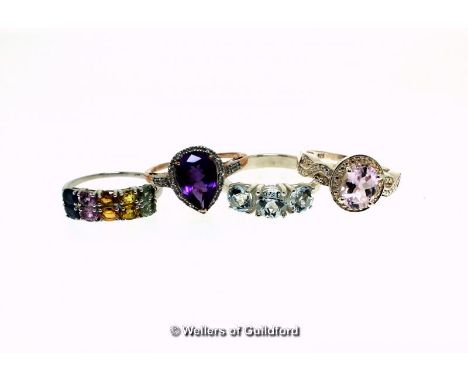 Four gem set dress rings, including a three stone aquamarine ring, ring size S, a pear shaped amethyst and white topaz cluste