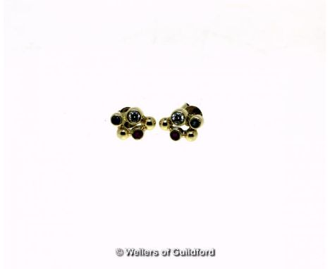 *Pair of yellow metal ear studs, tested as 14ct, each rubover set with a ruby, sapphire and white cubic zirconia (Lot subject