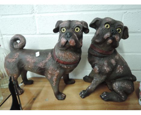 A pair of vintage pug dog figures one seated and one standing