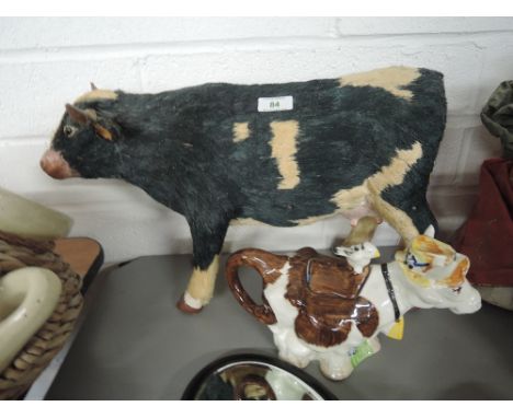 A vintage straw and papier mache figure of a cow and similar ceramic tea pot