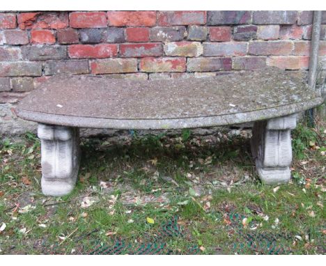A reclaimed crescent shaped garden bench raised on scrolled supports, 120 cm wide 