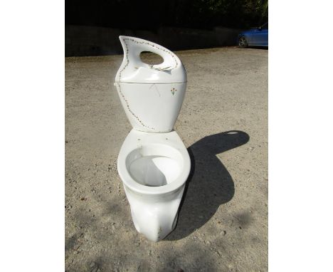 An unusual white ceramic lavatory and water system with shaped outline and trailing floral detail 