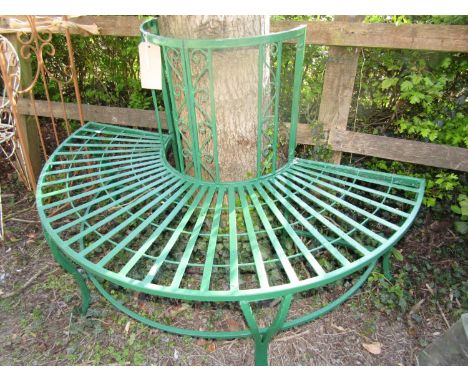 A semi circular ironwork garden seat with scrolled detail, 130 cm diameter, to accept a trunk 50 cm in diameter 