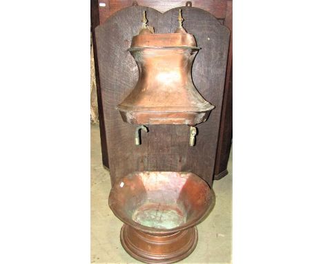 A 19th century copper water stoop, the body of waisted outline with engraved armorial and floral crest, with open basin below