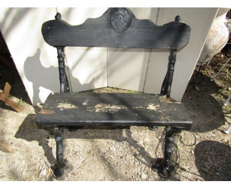 A pair of heavy Victorian cast iron bench ends of rustic twig form with later timber seat and back bearing cast iron plate Th