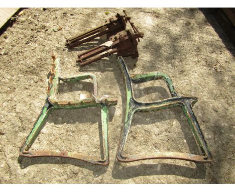 A pair of heavy cast iron bench ends together with two vintage vices 