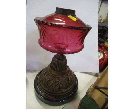 An oil lamp base, with cranberry glass oil reserve on a pressed metal base, height 14ins - glass is fine just some dents to t