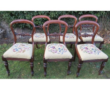 A set of six Victorian mahogany dining chairs, raised on turned front legs, with tapestry seats