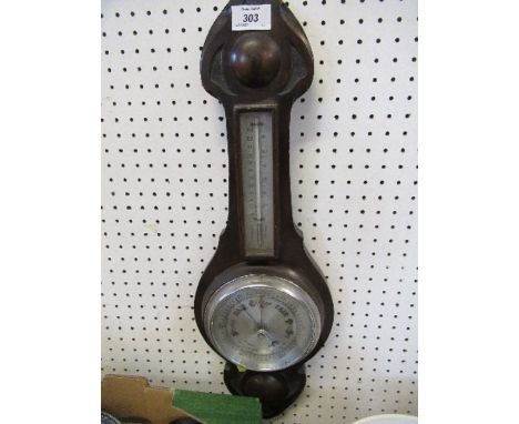 An oak barometer, with carved decoration, silvered dial and mercury filled barometer, height 23ins