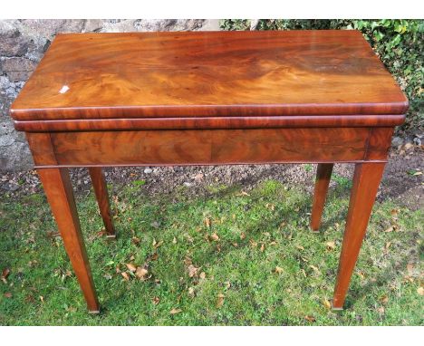 A 19th century mahogany fold over card table, of rectangular form, raised on square tapering legs and brass caps, 32ins x 16i