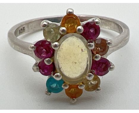 A silver multi stone cluster ring set with oval shaped central opal surrounded by assorted coloured gemstones. To include gar