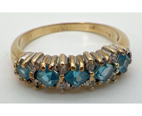 A 9ct gold eternity ring set with 5 square cut London blue topaz stones interspersed with small diamonds. Hallmark inside ban