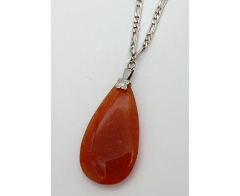 A teardrop shaped orange jade pendant on a silver 18" figaro curb chain. With lobster claw clasp, stamped 925 to both hook en