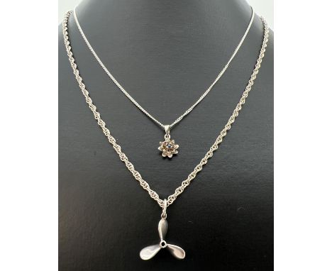 2 silver and white metal pendant necklaces. A small 925 silver flower pendant set with central sapphire, on a 17" silver fine