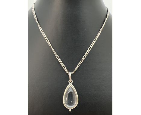 A clear quartz teardrop shaped pendant in a white metal mount, on an 18" 3mm figaro curb chain. Stamped 925 to joining link a