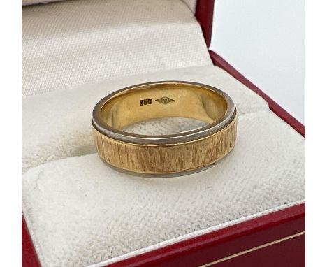 A 18K duo coloured gold band/wedding ring with bark effect pattern. Full hallmarks to inside of band. Band width 6mm, ring si