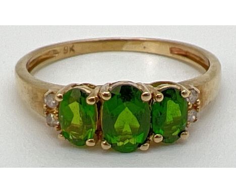 A 9ct gold chrome diopside 3 stone trilogy ring, set with 2 small diamonds to each shoulder. Stamped 9k inside band. Central 