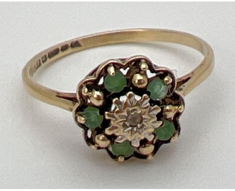 A vintage 9ct gold emerald and diamond cluster ring in an open work setting. Central illusion set diamond surrounded by 5 rou