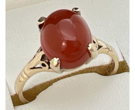 A vintage 9ct gold ring set with central oval cabochon of carnelian. Claw setting with decorative shoulders. Fully hallmarked